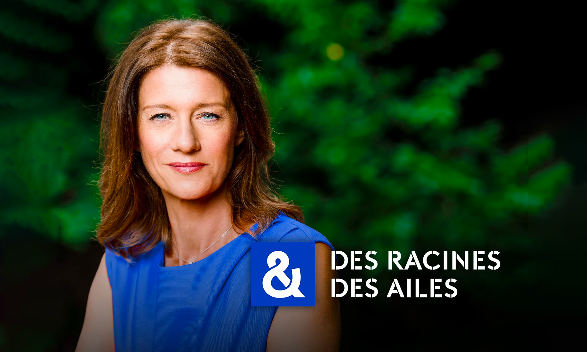 Carole Gaessler de face. Derrière elle un un fond verdoyant flou. Devant elle le logo de l'émission "Des racines & des ailes"