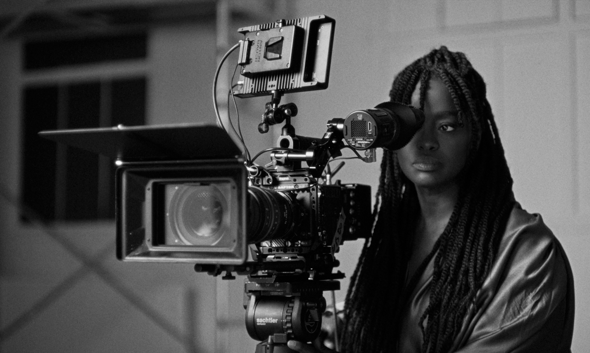 Aïssa Maïga derrière une caméra de cinéma. C'est une photographie en noir et blanc
